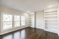 Living room with plenty of natural light and built in bookcases
