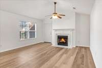 Stunning living room featuring a cozy gas fireplace, an open floor plan, and abundant natural light.