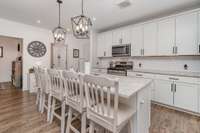 Featuring an extended island, granite countertops, and modern fixtures, this beautiful kitchen is an amazing addition to the unit.