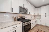 Stainless steel appliances adorn the kitchen while upgraded backsplash adds the finishing touch to the room.