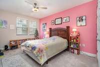 The guest room includes plush carpeting enhancing the comfort of the bedroom. An updated ceiling fan adds to the comfort and functionality of the space.