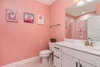 The guest bathroom adds convenience for guests, and offers a large mirror and vanity to make getting dressed a breeze.