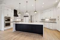 Calacatta Imperial Quartz waterfall island in Kitchen with leathered granite on surrounding counters.