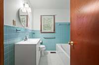 The full bathroom features tile flooring, a single vanity, and handicap accessible railings by the toilet and in the combination shower/tub. 6728 Jim Cummings Hwy Bradyville, TN 37026