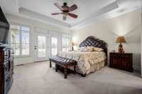 Primary bedroom w/ trey ceiling & plantation shutters