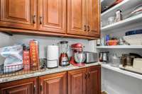 Walk in panty w/ more custom cabinets & shelving.