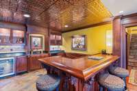L-shaped Bar with wet bar and kitchenette in basement