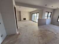 Open kitchen to living room with modern sliding doors leading to covered back porch.