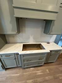 Stove area in kitchen with hood vent