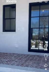 Herringbone brick pattern on front porch with modern metal front door