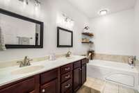 Large primary bath with double vanities and oversized spa tub.
