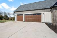 Spacious three-car garage featuring a two-car bay and a single-car bay. The single-car bay is currently utilized as a home gym, offering versatility for fitness enthusiasts or extra storage needs.