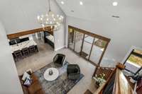 A breathtaking view! Overlooking the grand living space, this second-level landing showcases soaring ceilings, elegant lighting, and an open-concept design. The perfect vantage point to admire the seamless blend of luxury and comfort.