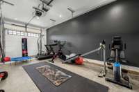The single-car garage bay has been transformed into a fully equipped home gym, providing a dedicated space for workouts with plenty of room for equipment and movement.