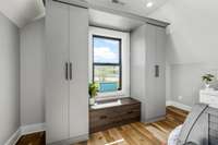 Second of four upstairs bedrooms, featuring brand-new custom California Closets, built-in storage, and a cozy window seat with stunning views.