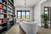 A cozy retreat! This stunning reading nook features custom built-in bookshelves, elegant cabinetry, and a chic chandelier. The perfect spot to unwind with a good book and enjoy a moment of tranquility.