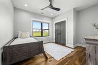 Bright and airy third upstairs bedroom featuring large windows with scenic views, a spacious closet, and stylish modern finishes.