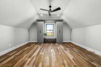 Spacious 4th bedroom with vaulted ceilings, modern fan, and brand-new California Closets. Features a private en-suite bath with herringbone tile, LED mirror, and sleek finishes for a stylish, functional retreat.