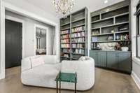 A cozy retreat! This stunning reading nook features custom built-in bookshelves, elegant cabinetry, and a chic chandelier. The perfect spot to unwind with a good book and enjoy a moment of tranquility.