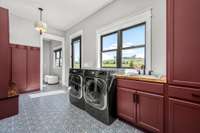 Style meets function! This spacious drop zone and laundry room features custom cabinetry, bold tile flooring, and abundant natural light. With built-in storage and a sink, it’s designed for convenience and organization.
