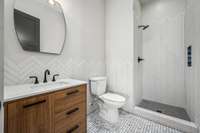 Full bathroom in the garage, conveniently located off the backyard. Features a sleek herringbone-tiled shower, modern vanity, and stylish finishes—perfect for post-outdoor cleanups or guest use.