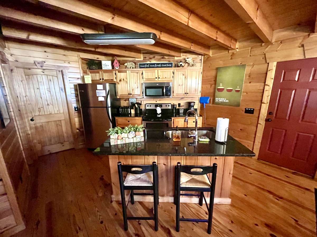 Kitchen with granite countertops, island with seating.