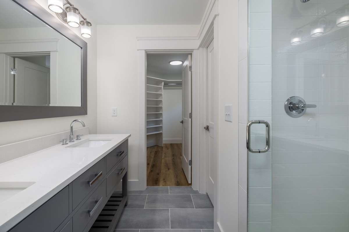 Primary Bathroom with double vanities and beautifully tiled shower