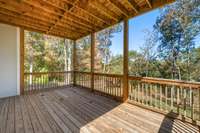1st level Deck – Outdoor deck with wood railing overlooks peaceful tree-lined views.