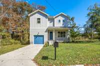 Covered front entry with black railing and a welcoming blue front door.