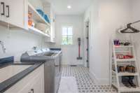 Wash sink, cabinetry, custom tile. Connects to primary closet & through a sliding door in the main hallway