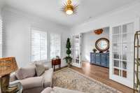 Opposite view of Office showing the glass French doors.  Hardwood flooring is rich in color.