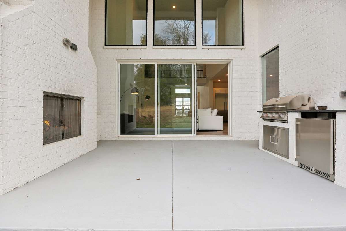 Outstanding outdoor living! Double stacked windows and sliders with 20 ft ceilings, fireplace, built in grilll