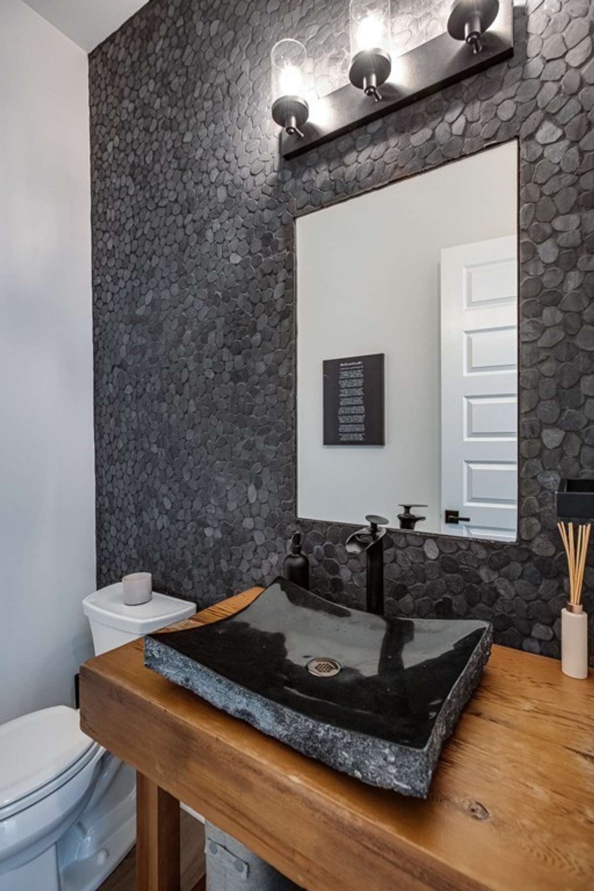 Powder room with designer sink, cabinetry and modern wall treatment.