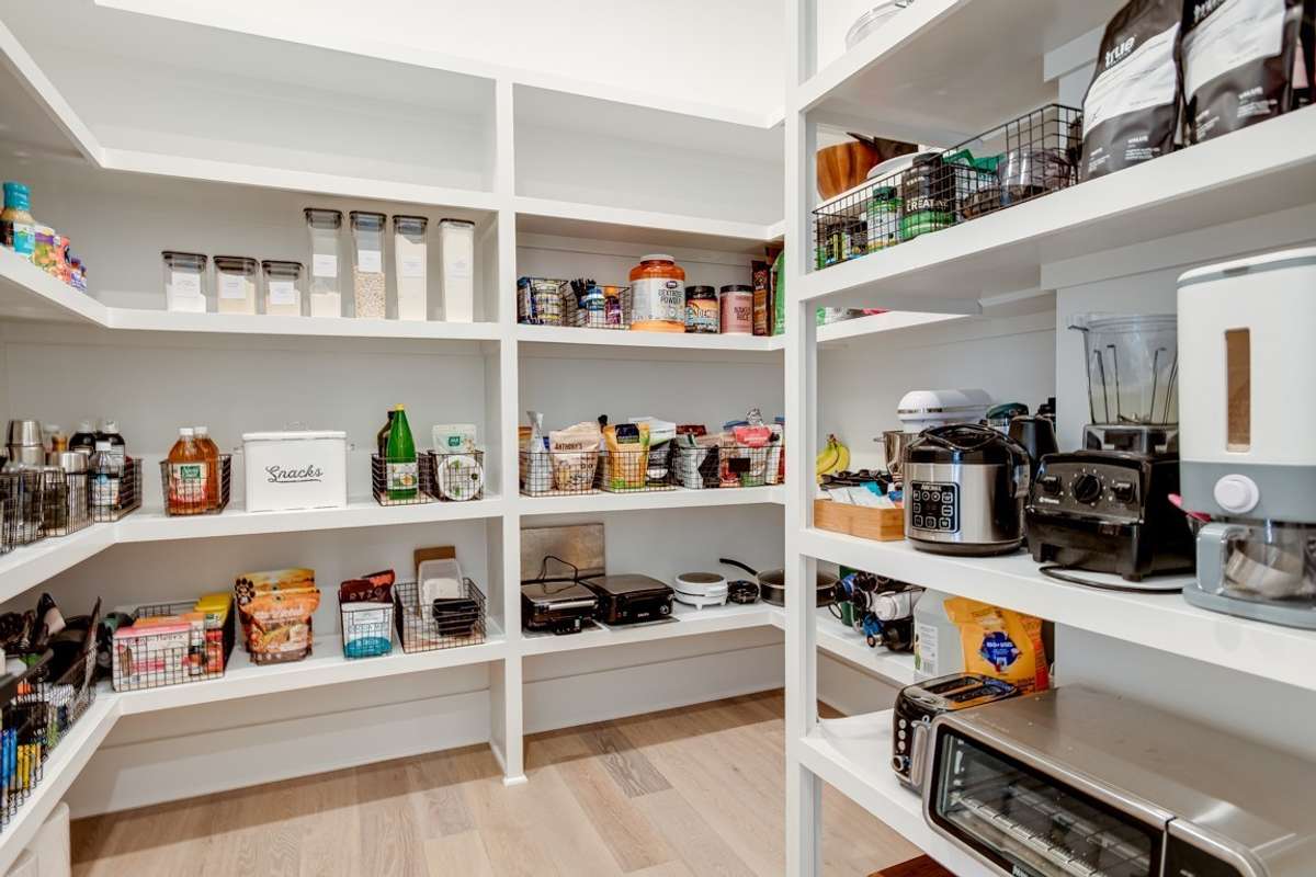 Extra large walk in pantry with custom wood shelving
