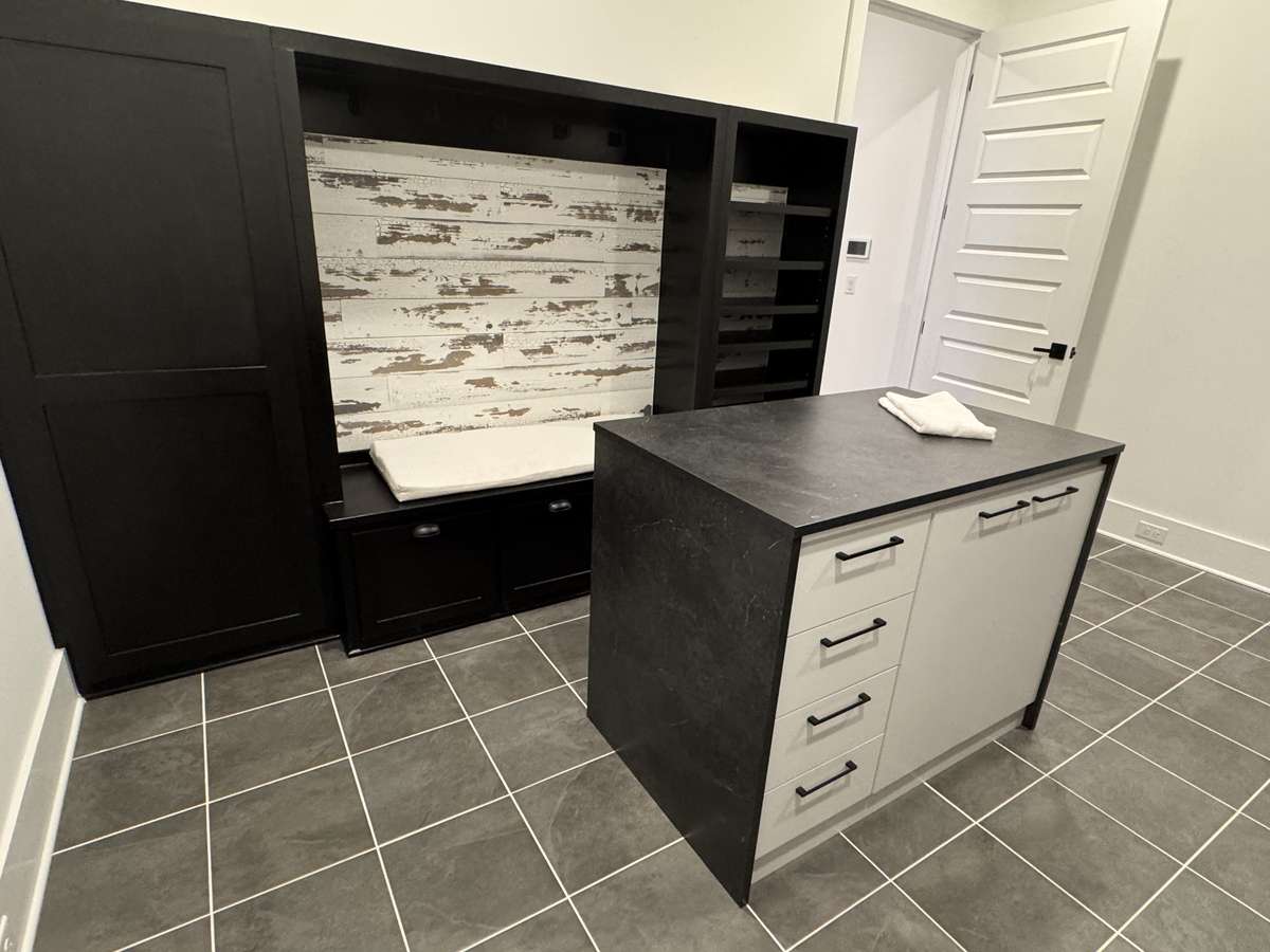 Modern Drop zone family ready room with sitting area, cubbies, shelving and island with storage. Perfect for organizing geeks!