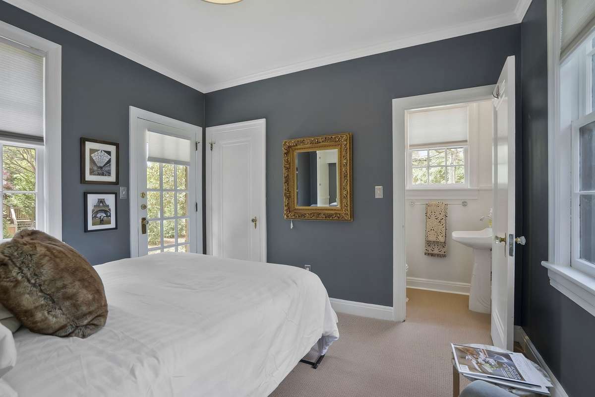 The light-filled 3rd Main Level Bedroom has a large closet, a half bath, and an outside entry door.