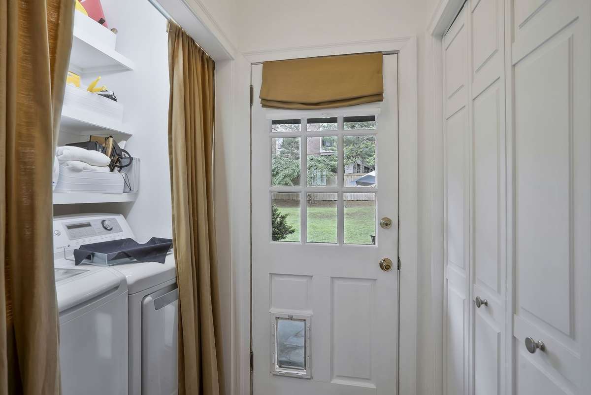 Laundry area right off the kitchen with Built-in shelves and backyard views!