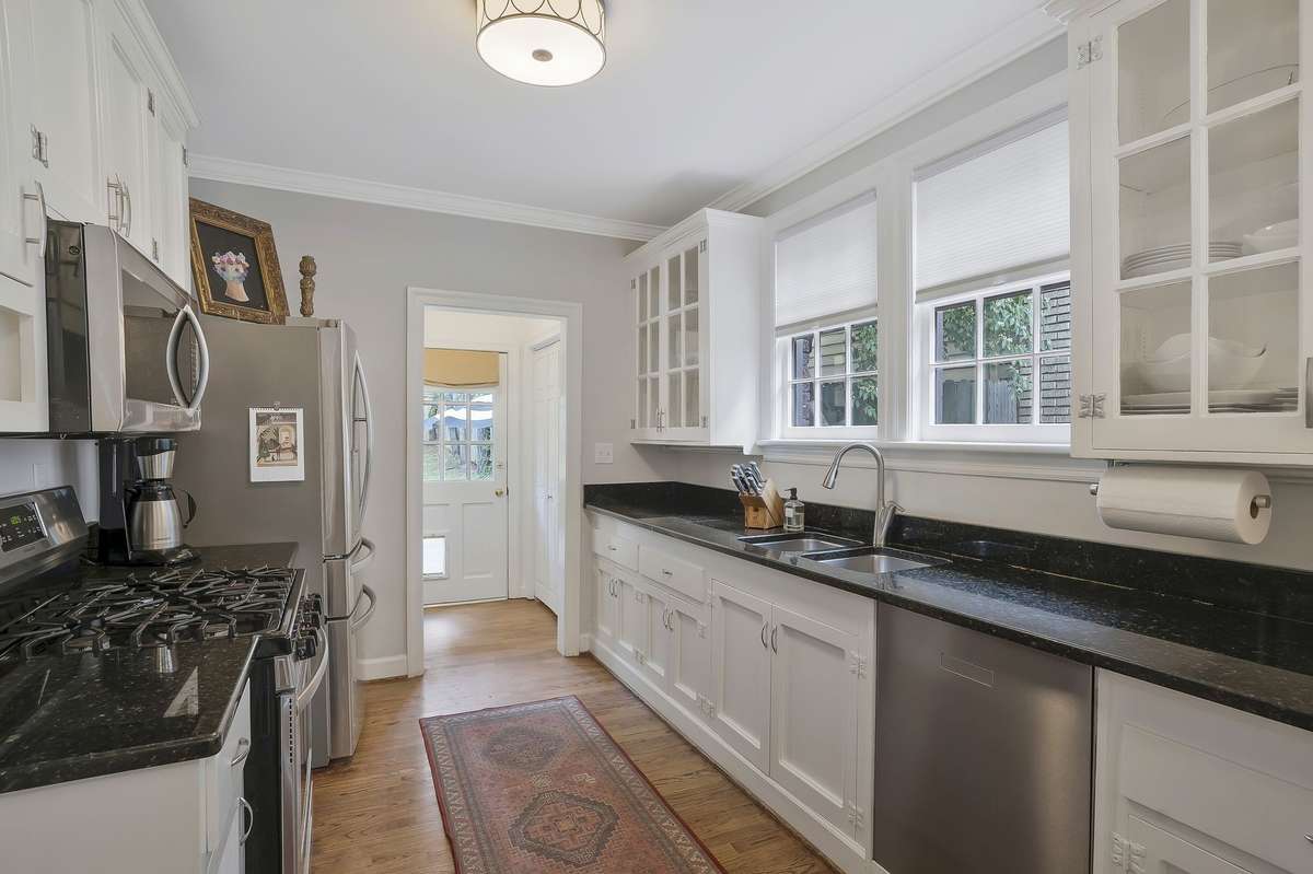 Galley kitchen with plenty of prep space, granite countertops, and stainless steel appliances.