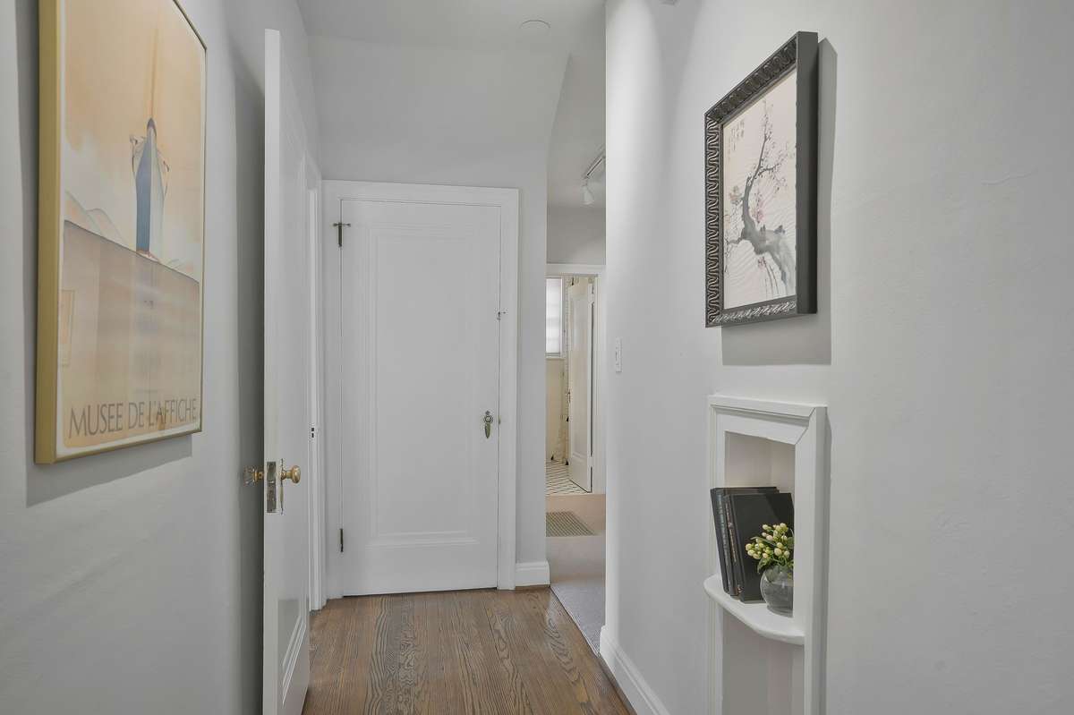 The main level central hallway, with Arched Ceilings and Track Lighting, guides you to the main-level bedrooms and baths, as well as the full basement.