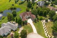 Aerial view shows the pond and the large common area behind this home.