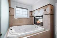 Double whirlpool professional tub in the primary with fireplace.