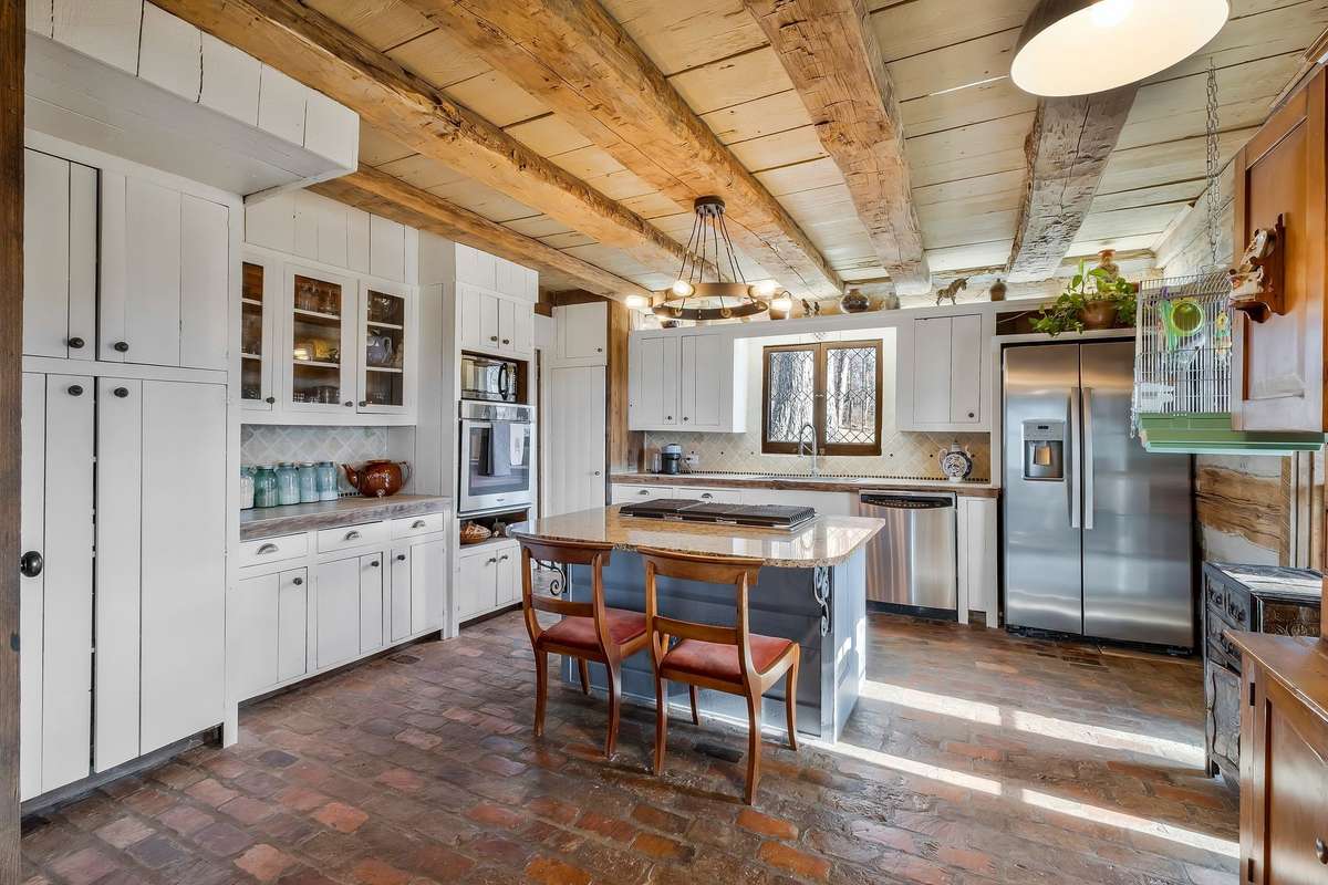 Braxton Dixon used reclaimed wood for the cabinets.The reclaimed brick floors extend into the kitchen.