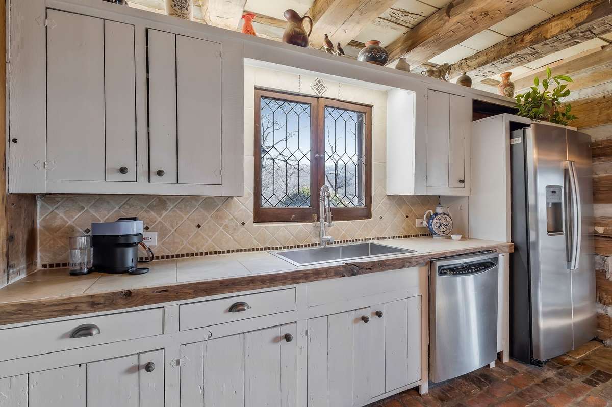 Vintage leaded glass windows add interest in the kitchen. There is a new sink and new refrigerator.