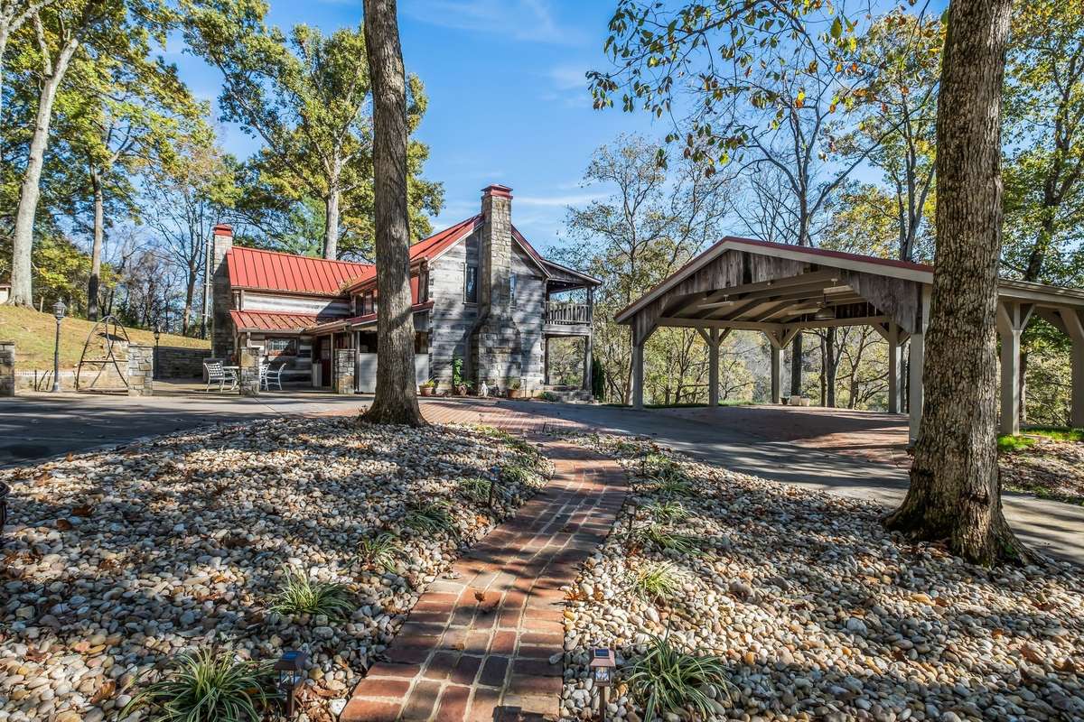 There is a circular driveway with a landscaped island and pathway in the middle.