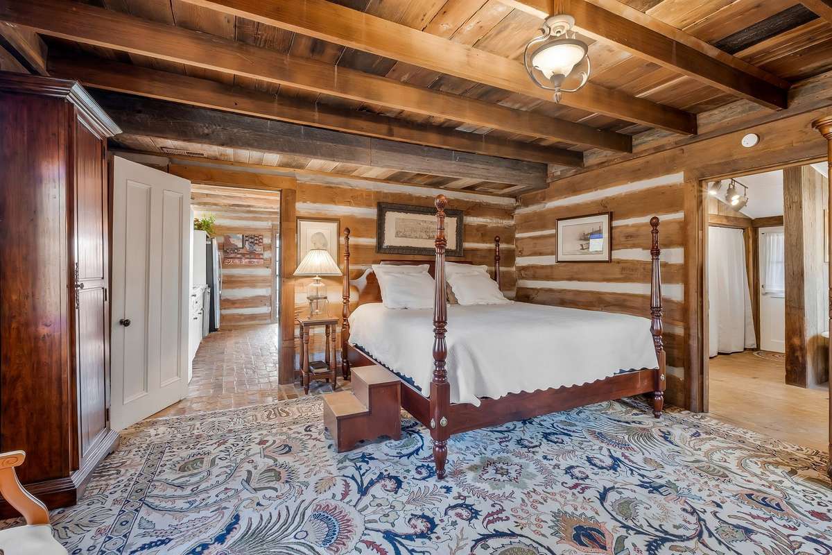 The primary bedroom is located in the logs from the reclaimed cabin from Alabama that was build around 1825.