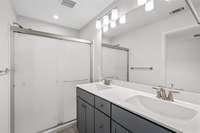 Primary Bath with double sinks and upgraded opaque shower door