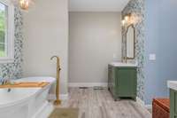 Spacious main-floor primary bedroom with a professionally updated, spa-like bathroom featuring a soaking tub, walk-in shower, double vanities, and large walk-in closets—your personal retreat awaits!
