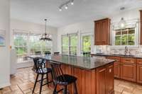 Enjoy views of the backyard oasis from this spacious kitchen, complete with a granite island, an abundance of cabinetry, upgraded backsplash, and a cozy eat-in breakfast area. Just steps away from the outdoors—perfect for everyday living!