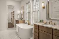 Grand primary bathroom with double vanities, a soaking tub, and oversized shower.