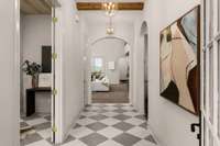 Stunning foyer with designer curated lighting and wooden beams.